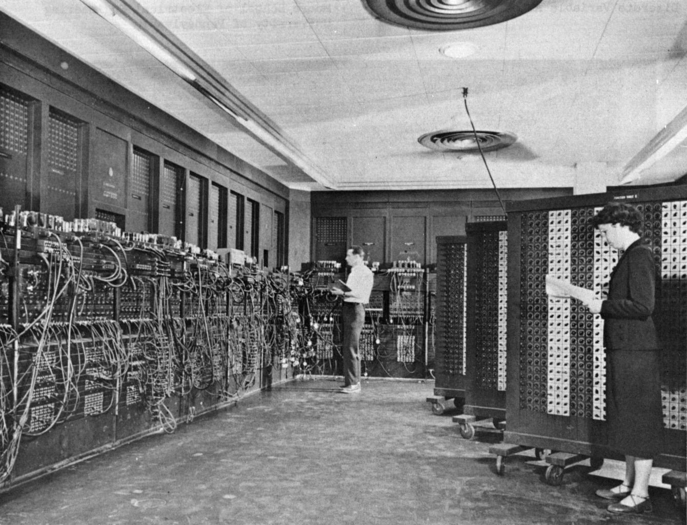 Historische Computeranlage ENIAC mit zwei Personen bei der Arbeit. Der ENIAC im Betrieb, Glenn A. Beck und Betty Snyder arbeiten gerade an der Maschine. (Bild: US Army)